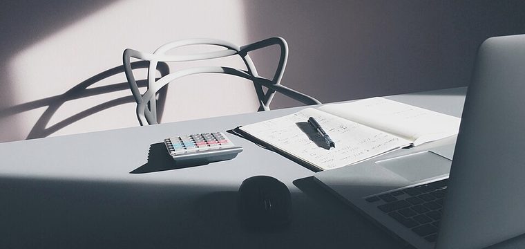 میز کار حسابدار با ماشین‌حساب و لپ‌تاپ