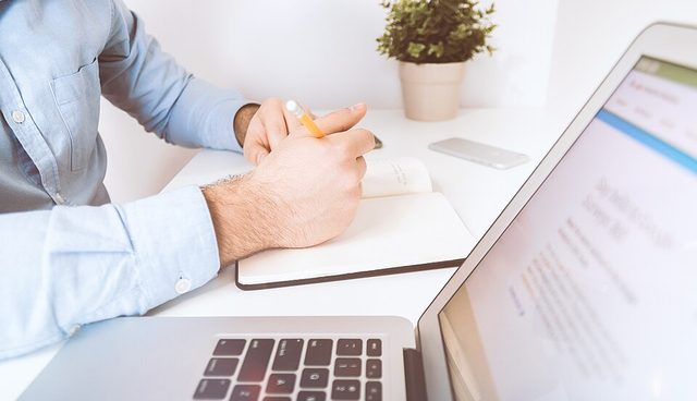هنرجو در حال یادگیری آنلاین با لپ‌تاپ و جزوه